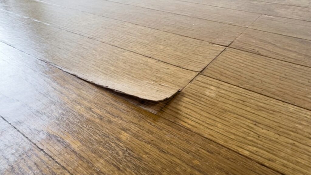 Close-up of warped wooden floorboards with raised edges