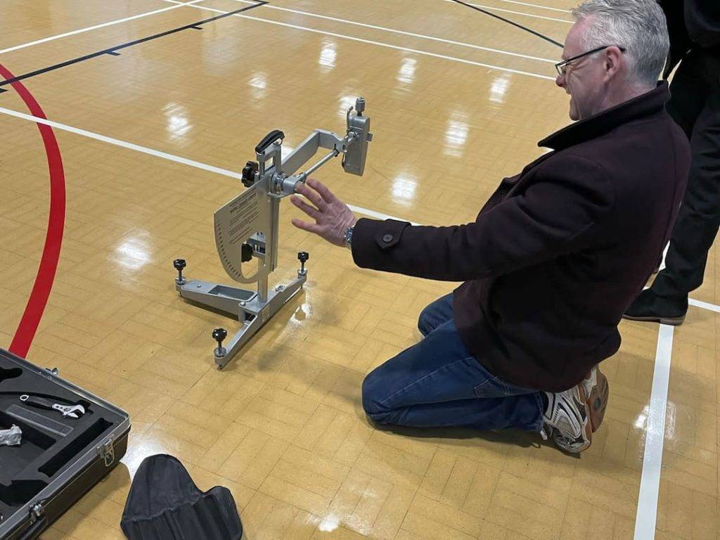 Man testing slip resistance of sports hall flooring