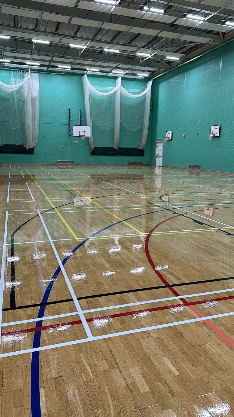 The newly refurbished sports hall floor at De Wint School, featuring fresh line markings and a glossy finish.