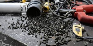 Close-up of spilled screws, tools, and a broken pipe.
