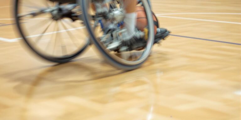 Wheelchair sports action on a durable court.