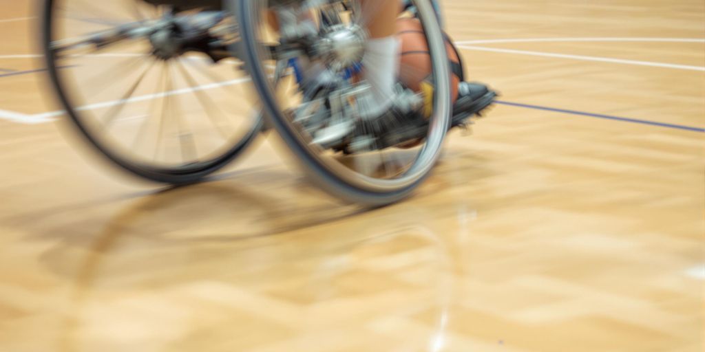 Wheelchair sports action on a durable court.