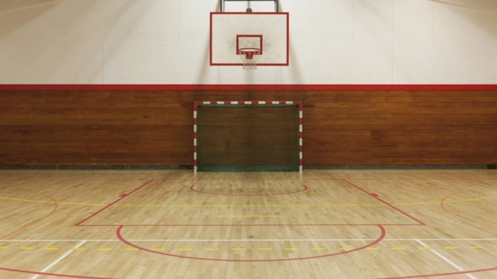 Indoor sports court with basketball hoop and handball goal