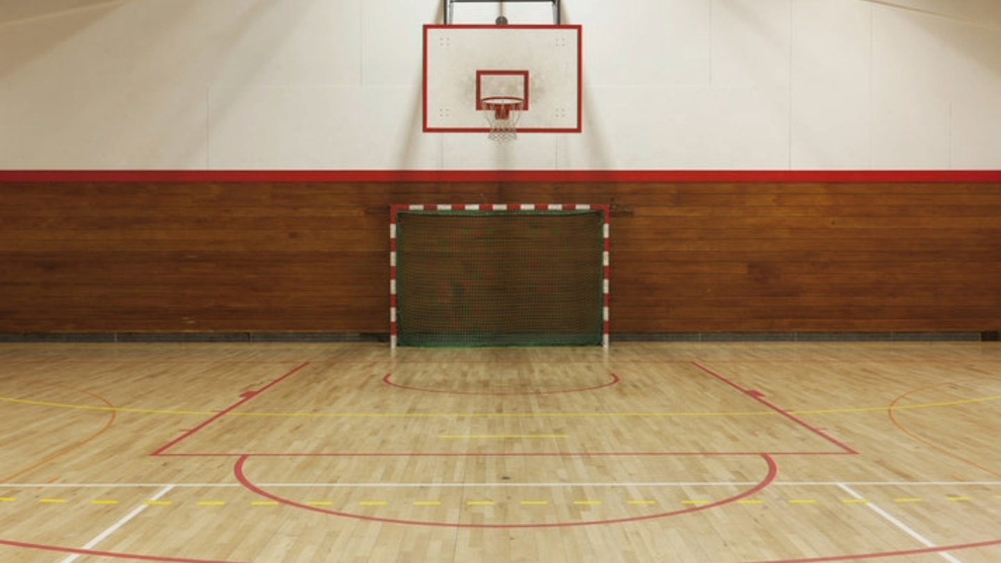 Indoor sports court with basketball hoop and handball goal